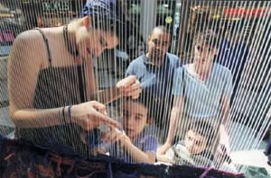 A young and talented fibre artist teaching tapestry weaving techniques to a new generation of young weavers